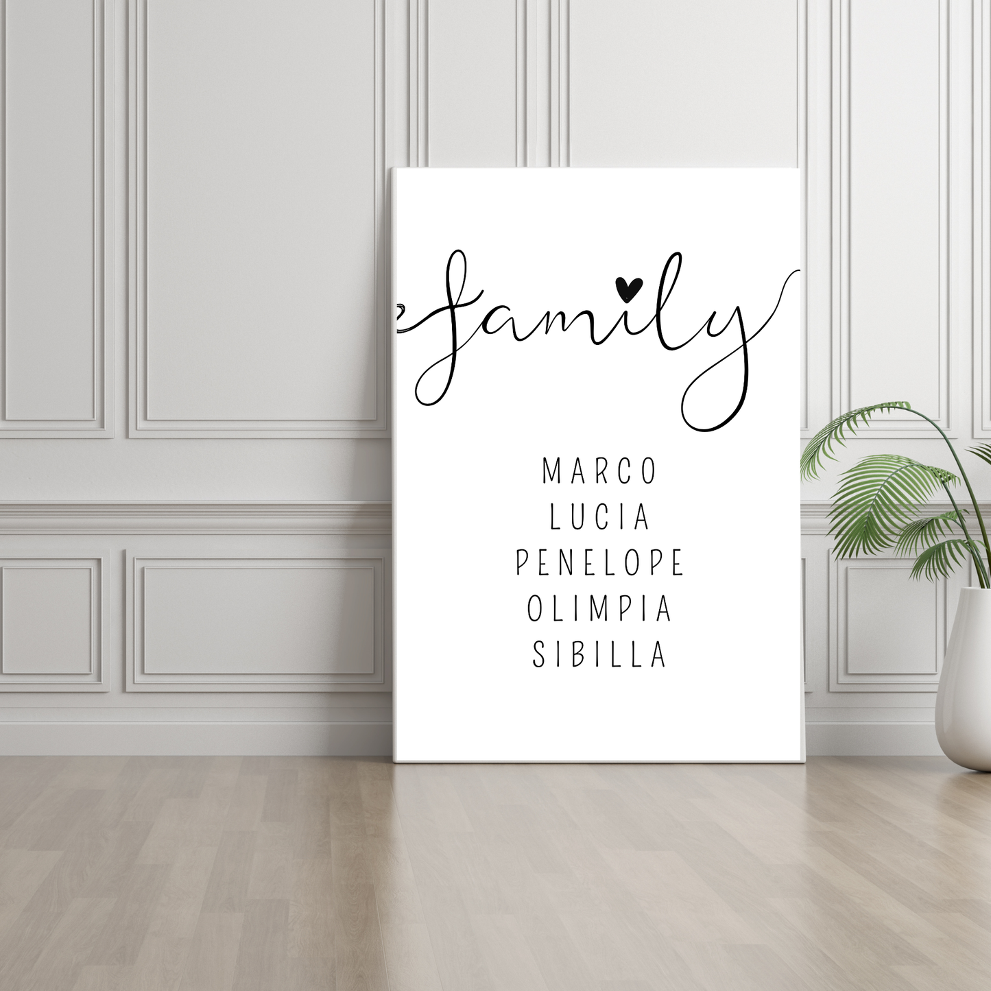 Grafica stampabile FAMILY personalizzabile con il nome dei membri della famiglia stampata su tela e appoggiata ad un muro con boiserie.