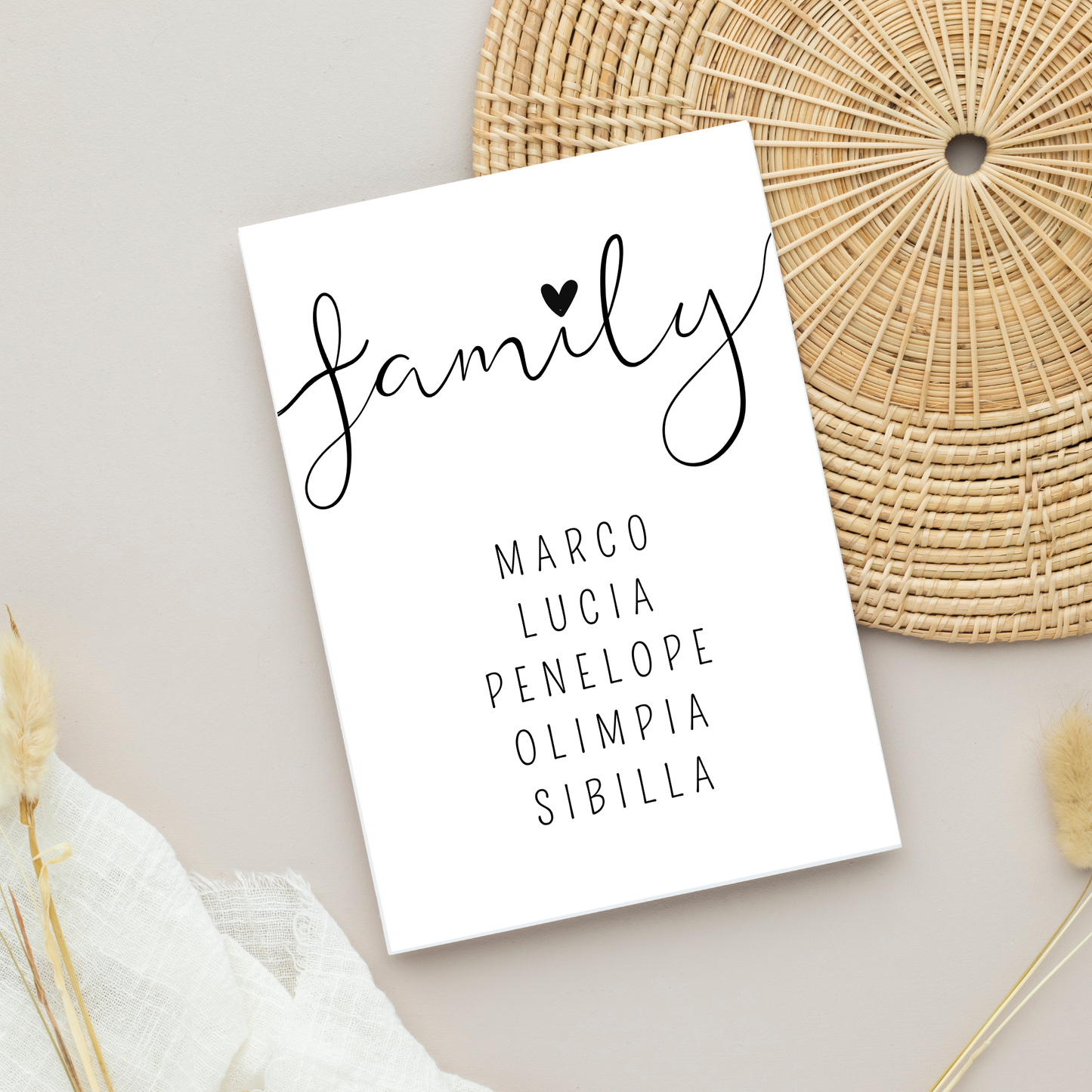 Stampa personalizzabile FAMILY appoggiata su piano e dettagli naturali.