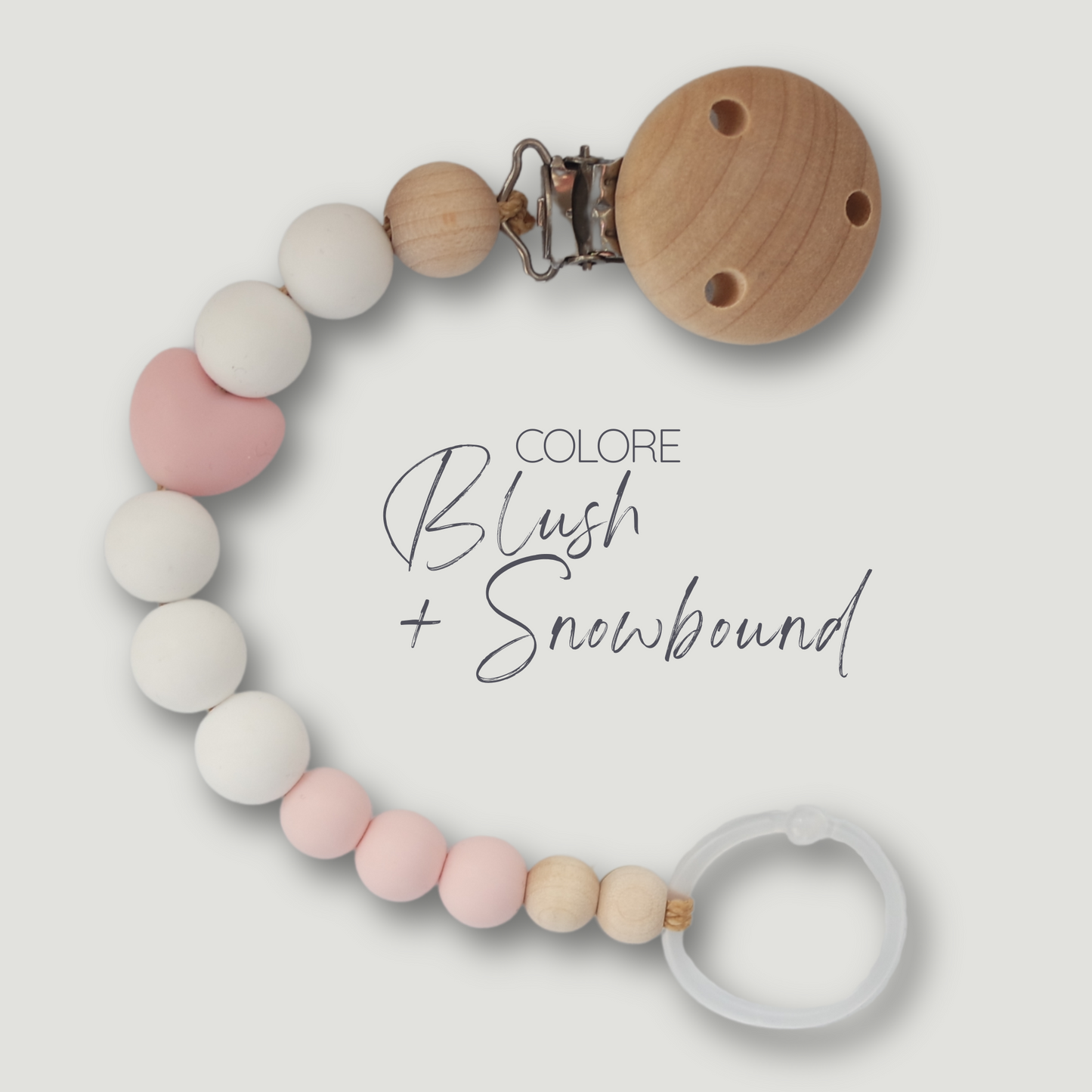 Catenella portaciuccio in silicone e legno, con perla centrale a forma di cuore nella variante colore blush + snowbound.