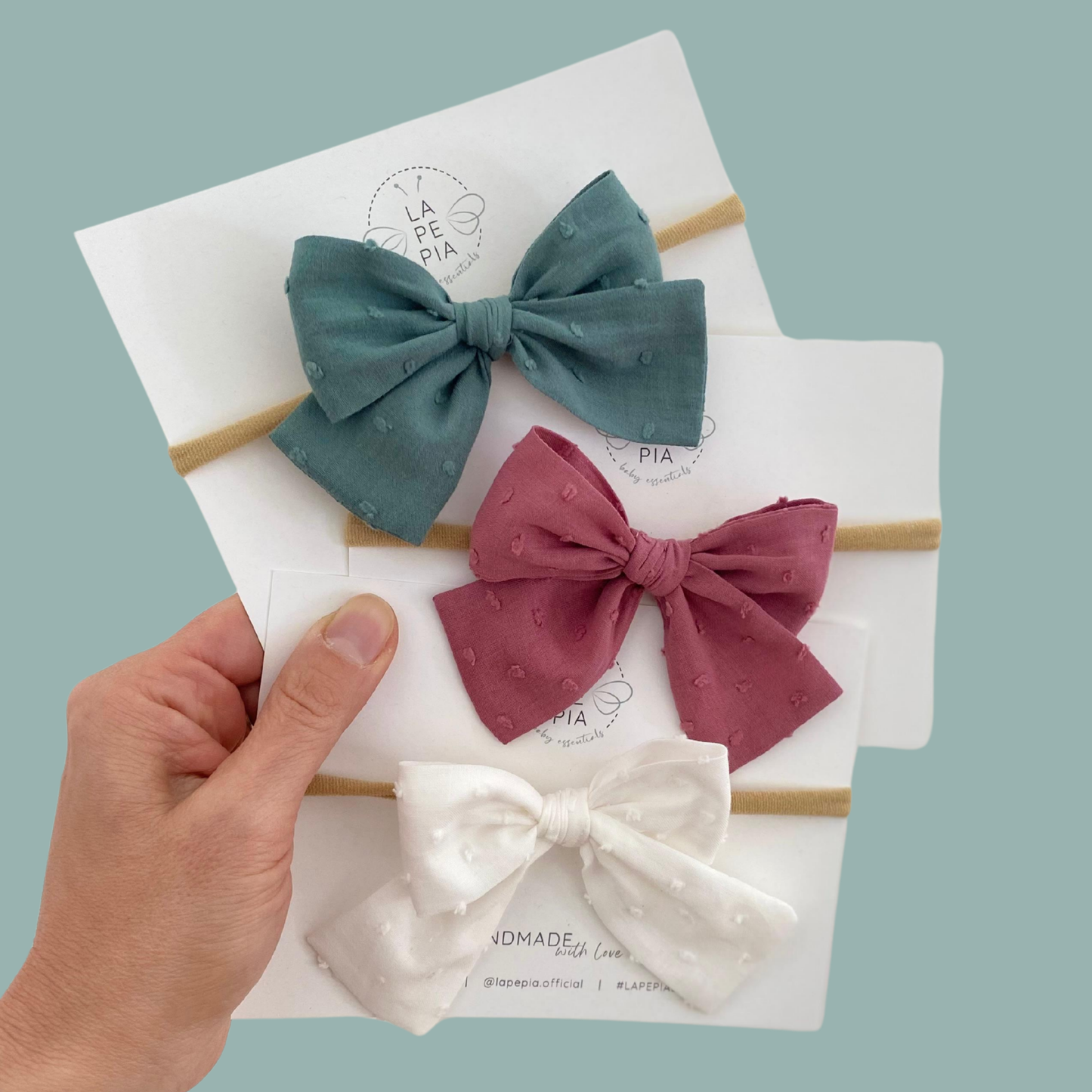 Collezione di fiocchi per capelli Classic Bow Plumetis in tre colori: vintage mauve, soft white e antique green. Eleganti accessori per capelli da neonata e bambina.