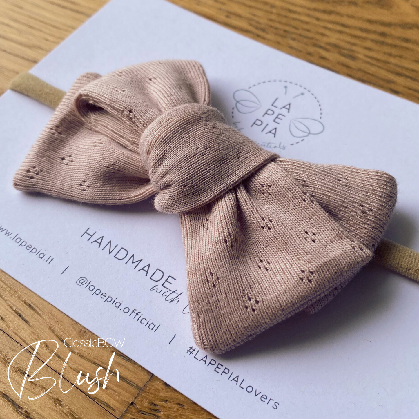 Fiocco in jersey di cotone annodato su fascia in nylon nel colore Blush. Confezionato su cartolina logata Lapepia.