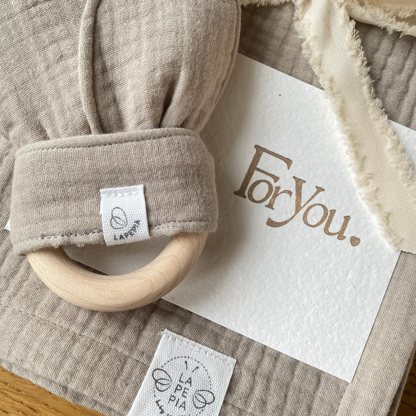 Set regalo Little Wonder Box 'Sweet Dreams' nella variante colore Beige, composto da copertina in mussola beige, dou dou beige con anello dentizione e sacchettino protettivo in cotone. Dettaglio della cartolina in carta di cotone e stampa LetterPress. LAPEPIA.