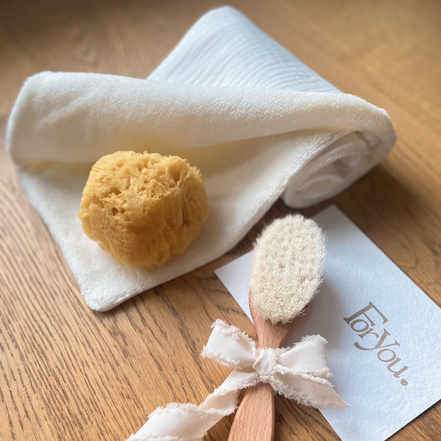 Set regalo Little Wonder Box 'Wellness Essentials' nella variante Cream, con telo double face color cream, spazzola in legno con setole naturali, spugna di mare e sacchettino protettivo in cotone. LAPEPIA.
