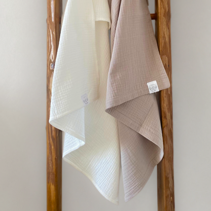 Copertine in mussola di cotone nei colori beige e cream annodate su una scala vintage.