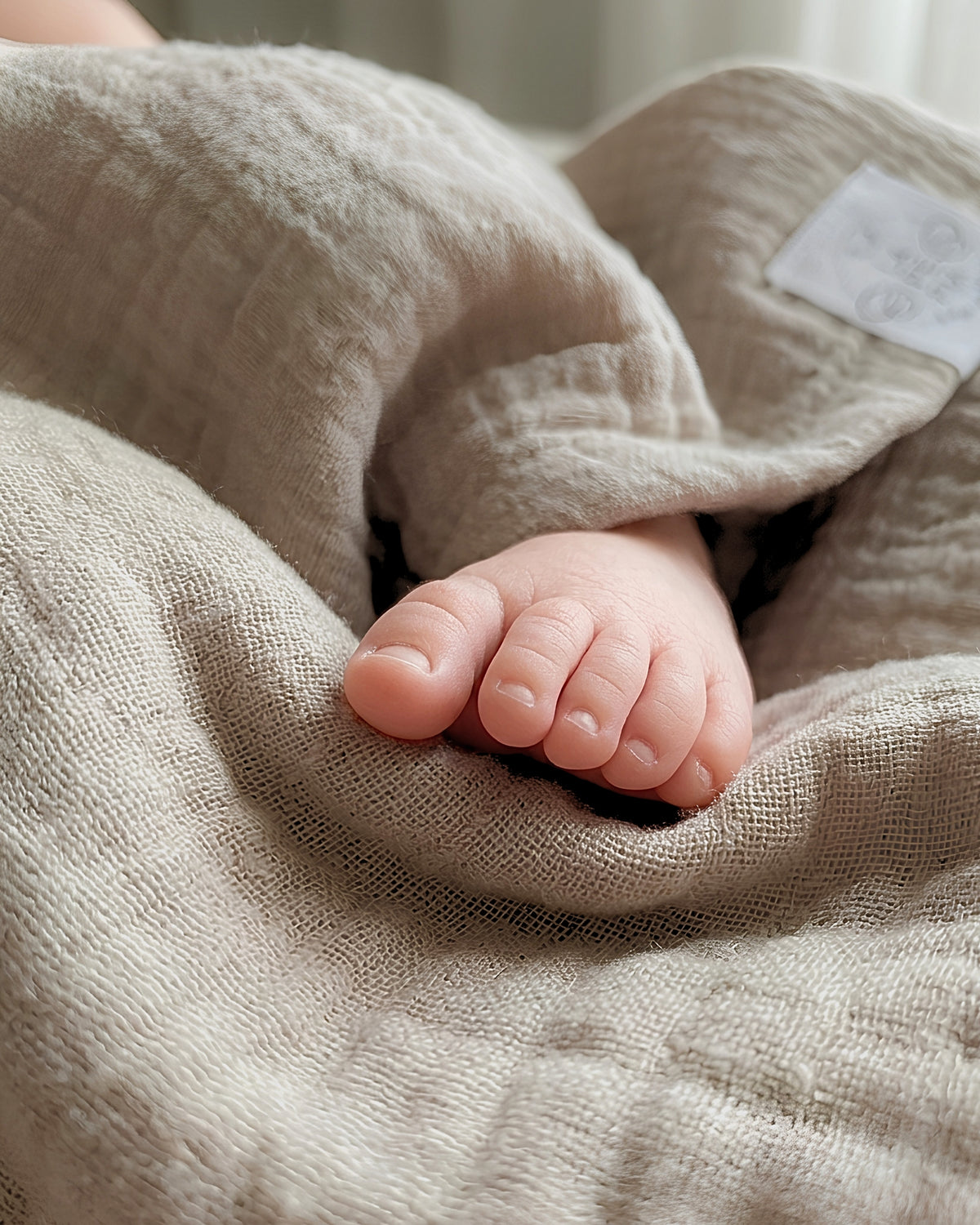 Dettaglio copertina in mussola di cotone biologico, piedini del neonato
