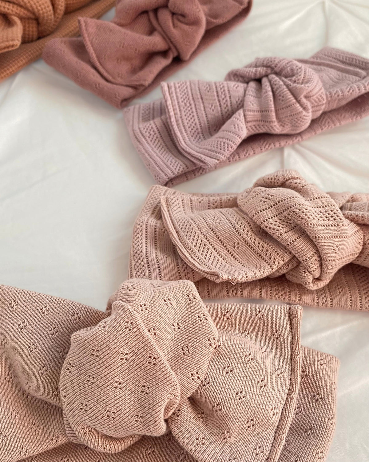 Dettaglio della trama del tessuto pointelle in jersey di cotone per fascia da neonata rosa
