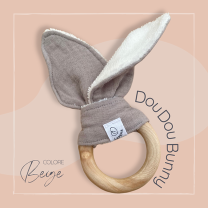 Doudou a forma di orecchie di coniglio in mussola e spugna di bamboo, con anello dentizione in legno colore beige.