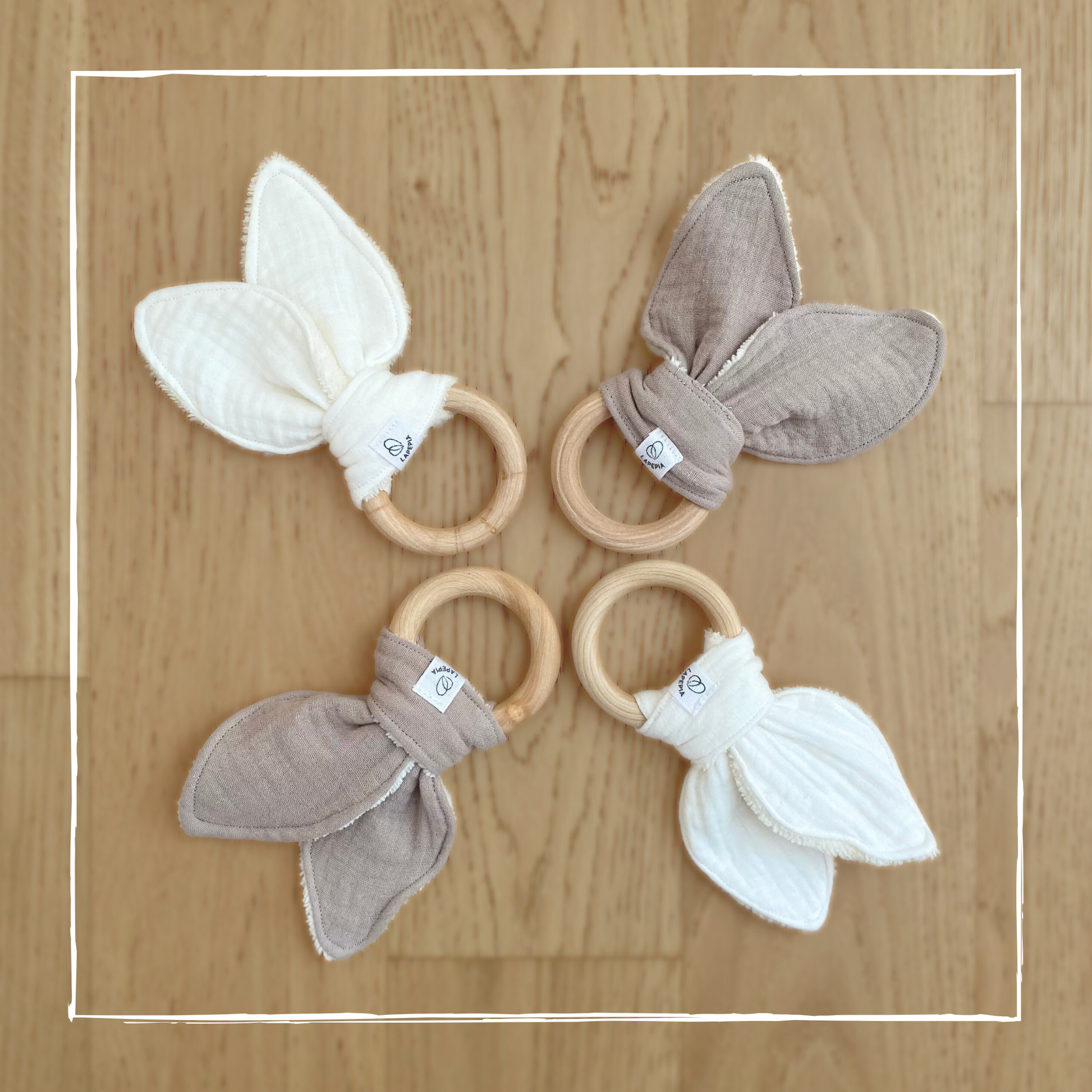 Doudou a forma di orecchie di coniglio in mussola e spugna di bamboo, con anello dentizione in legno nei colori cream e beige