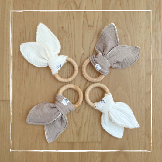 Doudou a forma di orecchie di coniglio in mussola e spugna di bamboo, con anello dentizione in legno nei colori cream e beige