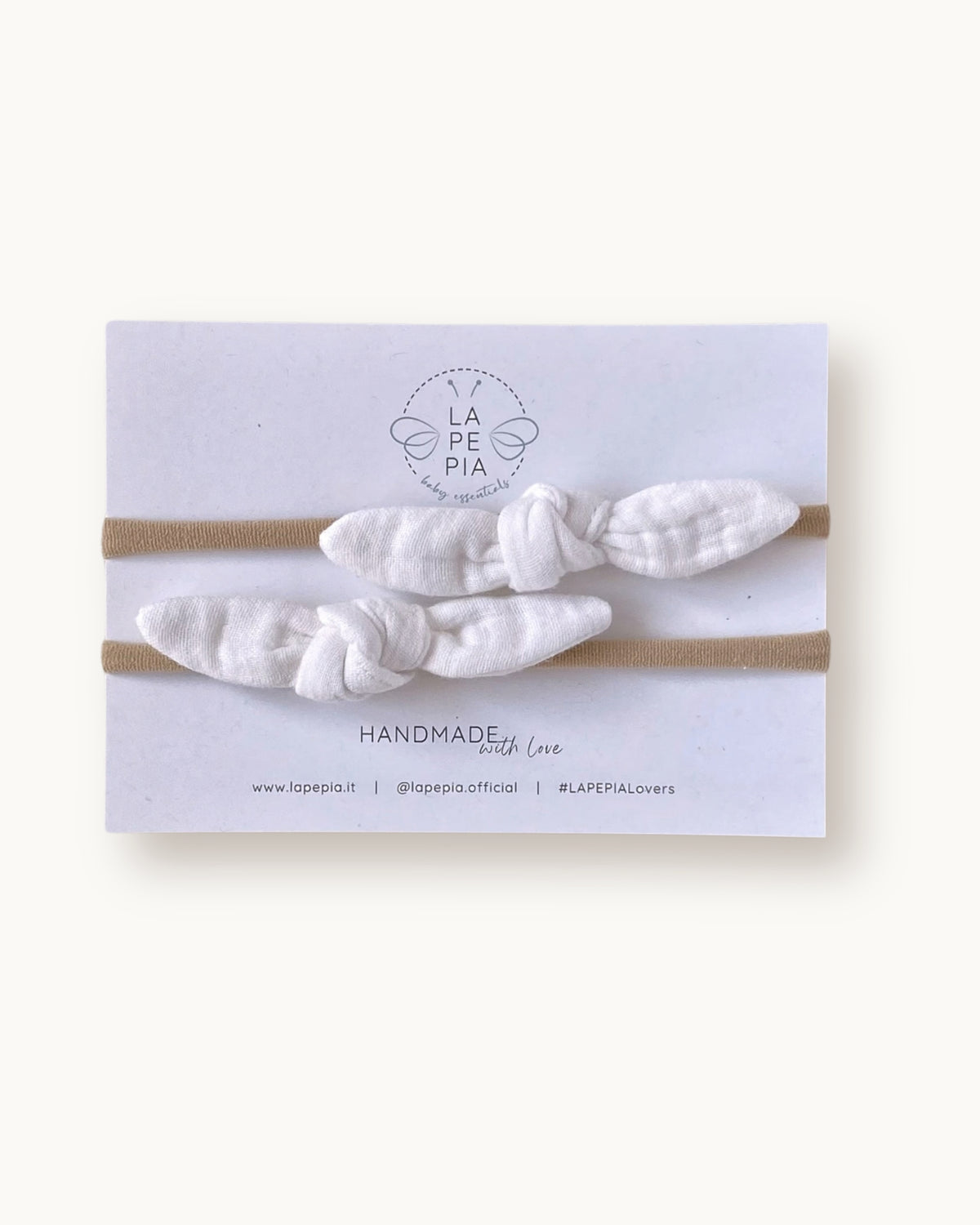 Set di due fasce per neonata con nodo TinyKnot in mussola di cotone color avorio su fascia morbida in nylon.