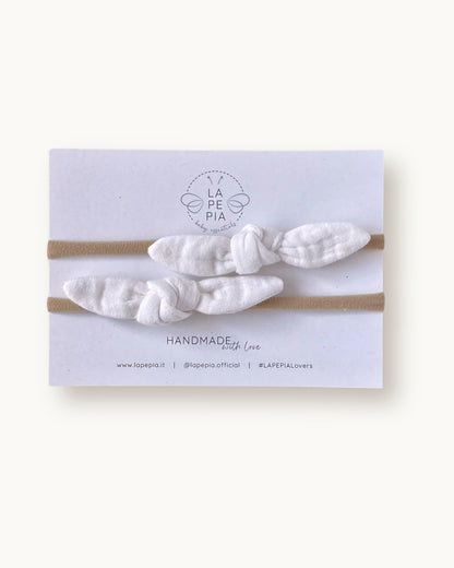 Set di due fasce per neonata con nodo TinyKnot in mussola di cotone color avorio su fascia morbida in nylon.