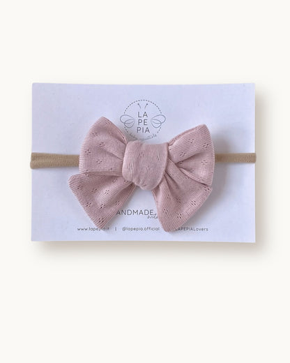 Fiocco per capelli Classic Bow color rosa cipria in cotone lavorato, fatto a mano su fascia morbida per neonata.