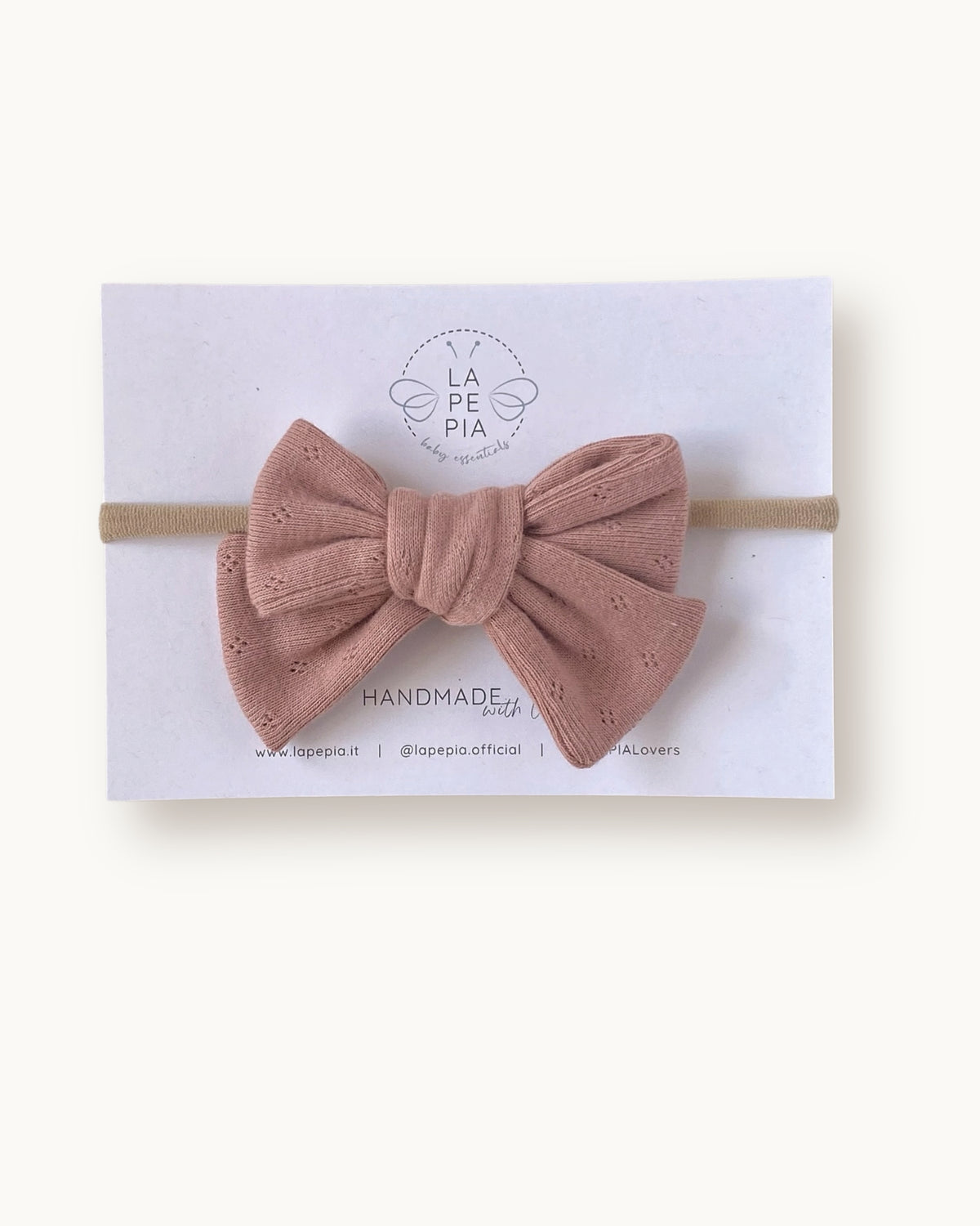 Fiocco per capelli Classic Bow color rosa pesca in cotone lavorato, fatto a mano su fascia morbida per neonata.