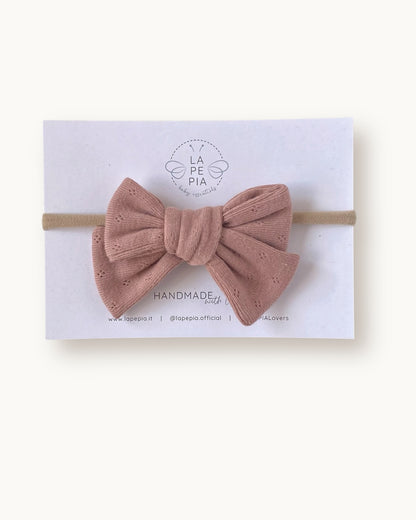 Fiocco per capelli Classic Bow color rosa pesca in cotone lavorato, fatto a mano su fascia morbida per neonata.