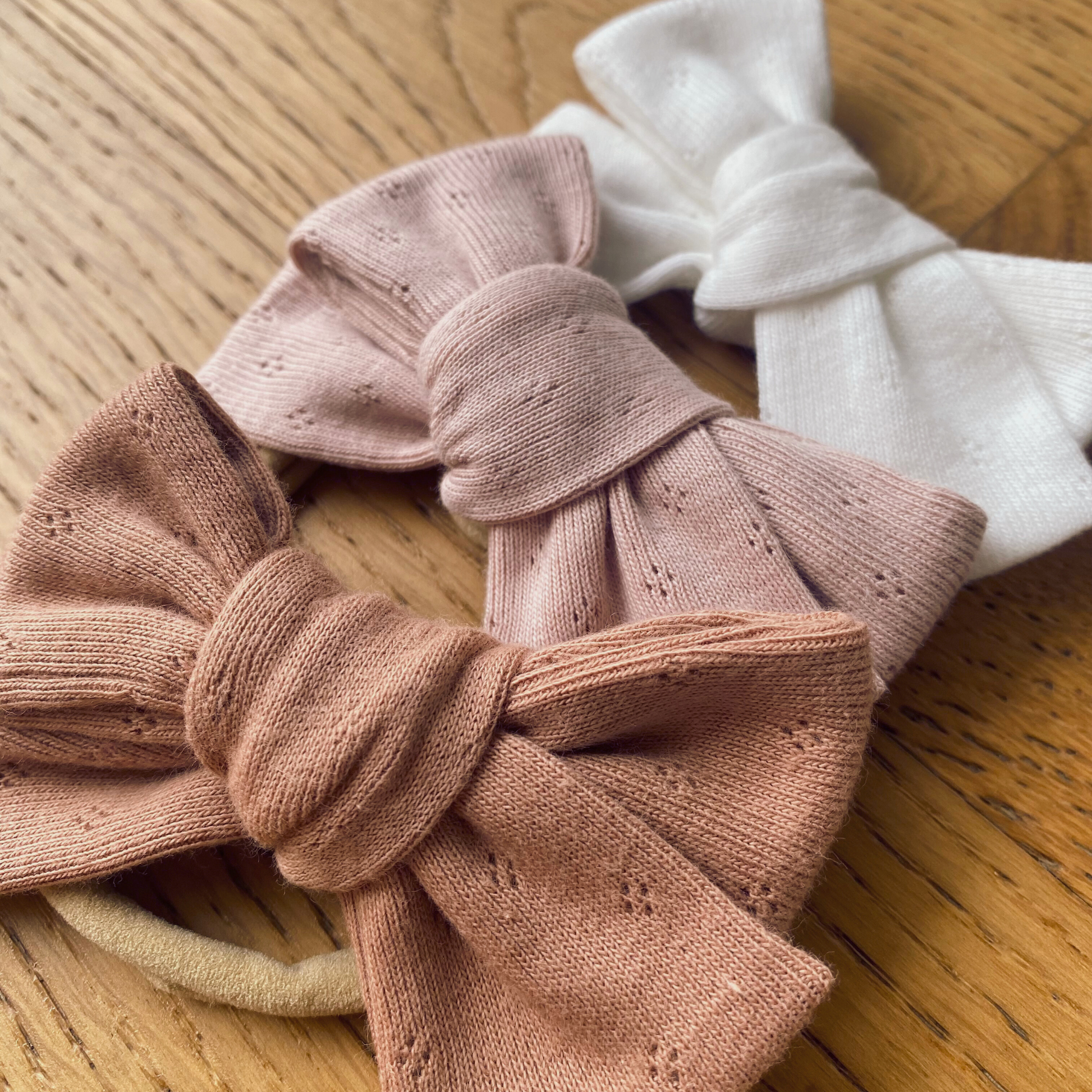 Fiocco in jersey di cotone annodato su fascia in nylon nei colori Peachy Sunset, Blush e Snowbound.