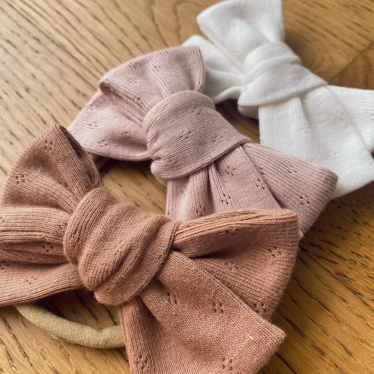 Fiocco in jersey di cotone annodato su fascia in nylon nei colori Peachy Sunset, Blush e Snowbound.