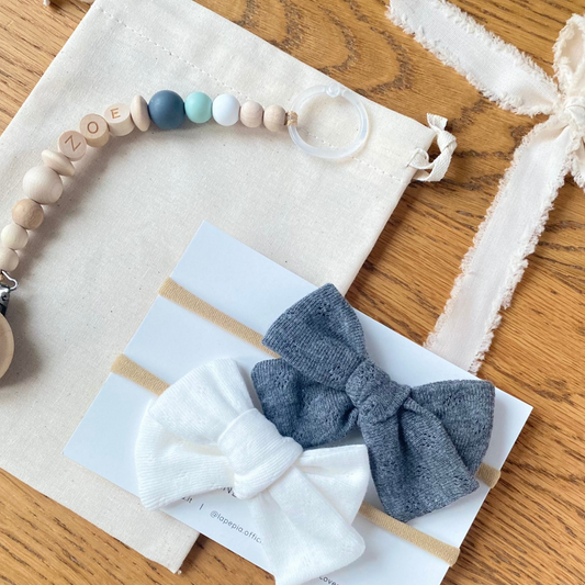 Set regalo Little Wonder Box 'NameIT & LoveIT' composto da 2 fiocchi per capelli, catenella portaciuccio personalizzabile con nome e  sacchettino protettivo in cotone. LAPEPIA.