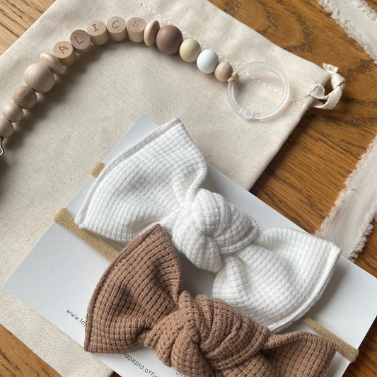 Set regalo Little Wonder Box 'NameIT & LoveIT' composto da 2 fiocchi per capelli, catenella portaciuccio personalizzabile con nome e  sacchettino protettivo in cotone. LAPEPIA.