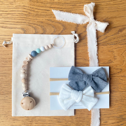 Set regalo Little Wonder Box 'NameIT & LoveIT' nella variante colore Seafoam Harmony, composto da 2 fiocchi per capelli, catenella portaciuccio personalizzabile con nome e  sacchettino protettivo in cotone. LAPEPIA.