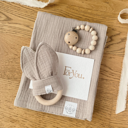 Set regalo Little Wonder Box 'NewBorn Essentials' nella variante Beige composto da copertina in mussola beige, Dou Dou beige con anello dentizione, catenella portaciuccio honey maple e sacchettino protettivo in cotone. LAPEPIA.