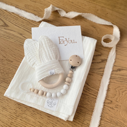 Set regalo Little Wonder Box 'NewBorn Essentials' nella variante Cream composto da copertina in mussola cream, Dou Dou cream con anello dentizione, catenella portaciuccio snowbound e sacchettino protettivo in cotone. LAPEPIA.