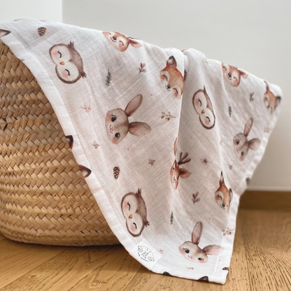 Mussola di cotone 70x70 variante Bosco Incantato che esce da una cesta in paglia, morbida e delicata per neonati e bambini