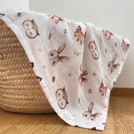 Mussola di cotone 70x70 variante Bosco Incantato che esce da una cesta in paglia, morbida e delicata per neonati e bambini