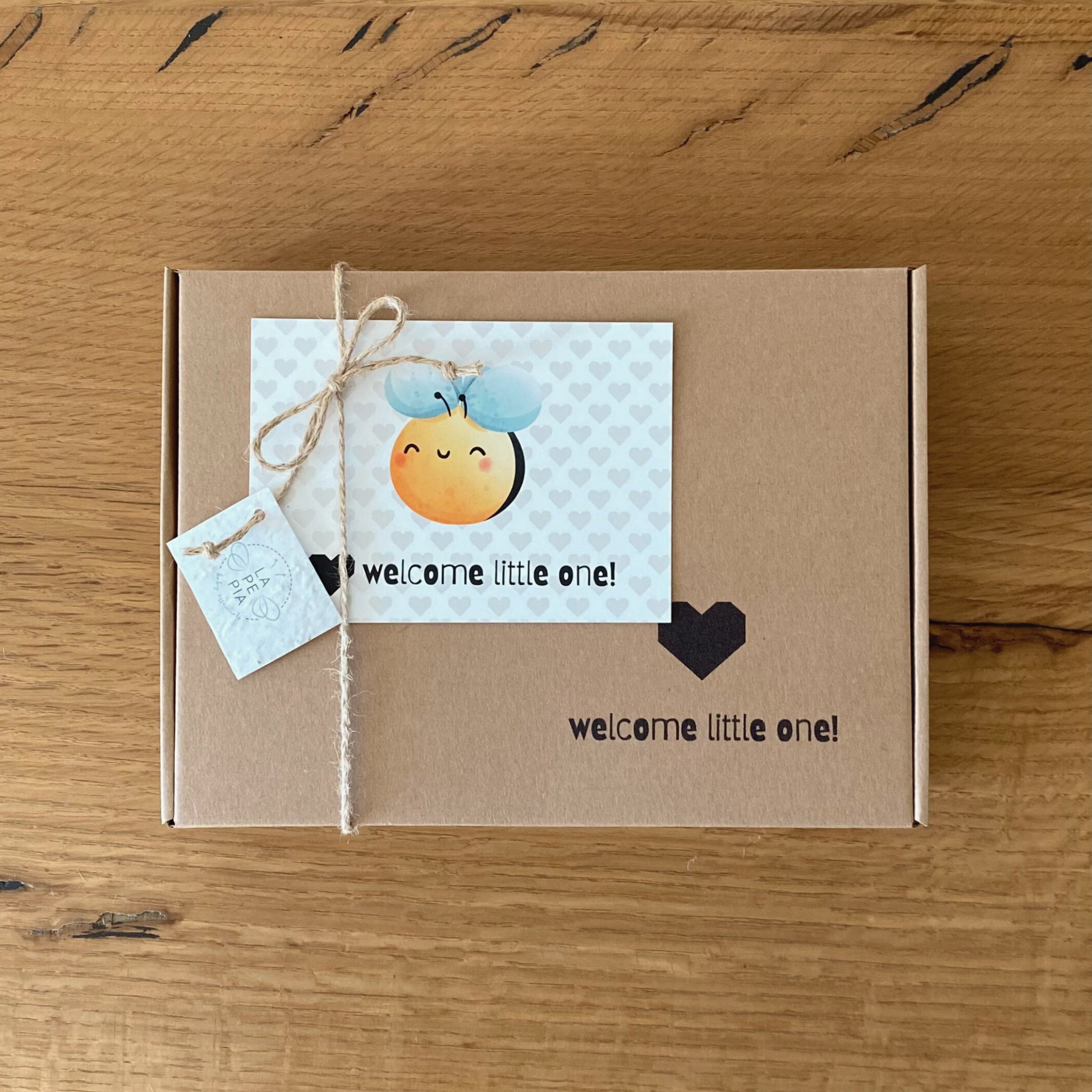 Scatola regalo in cartone con personalizzazione "WELCOME LITTLE ONE!", chiusa con cordoncino in juta e carolina personalizzabile.