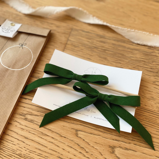 Fiocchi di velluto verde del set Velvet Holly, confezionati in un sacchetto di carta kraft decorato a mano, perfetto come idea regalo di Natale. LAPEPIA.